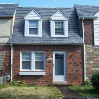 A brick house with a gray roof in Glebewood Village